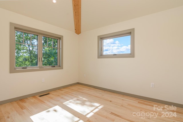 spare room featuring hardwood / wood-style floors, beamed ceiling, and a healthy amount of sunlight