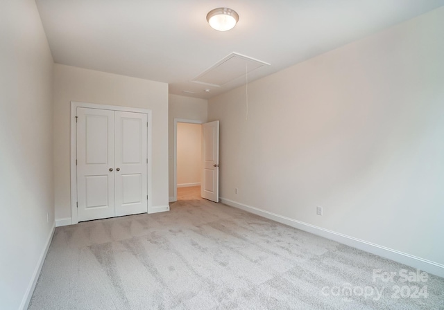 unfurnished bedroom with light carpet and a closet