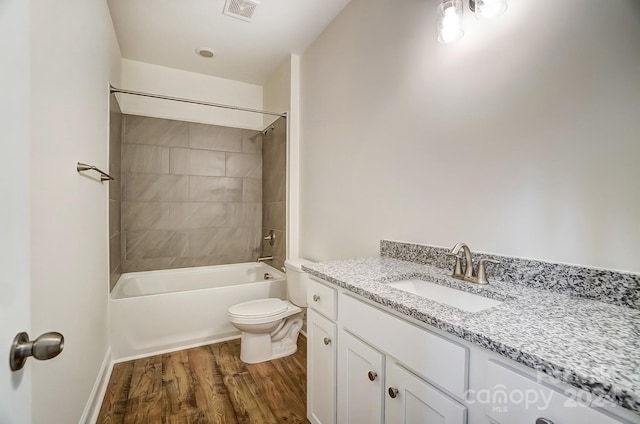 full bathroom featuring toilet, tiled shower / bath, hardwood / wood-style floors, and vanity