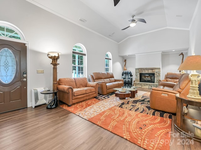 living room featuring crown molding, a fireplace, and hardwood / wood-style flooring