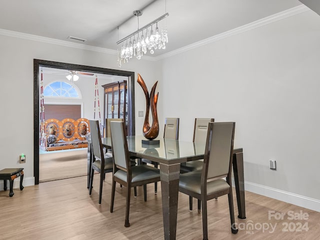 dining area with crown molding and light hardwood / wood-style flooring