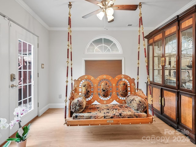 living area with ceiling fan, a healthy amount of sunlight, crown molding, and light wood-type flooring