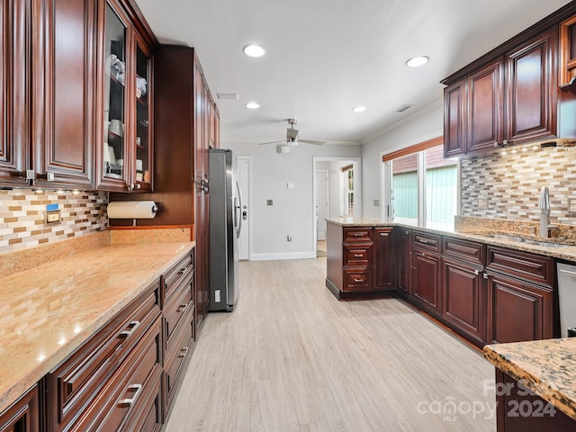 kitchen featuring light stone countertops, sink, backsplash, and appliances with stainless steel finishes