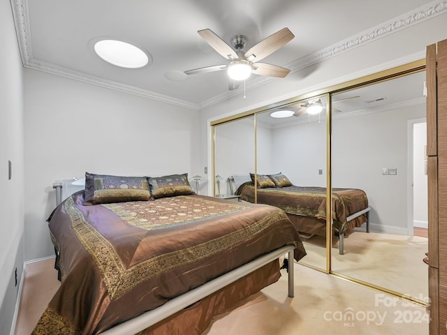 bedroom featuring ceiling fan, light carpet, a closet, and crown molding