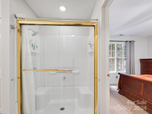 bathroom with a textured ceiling and an enclosed shower