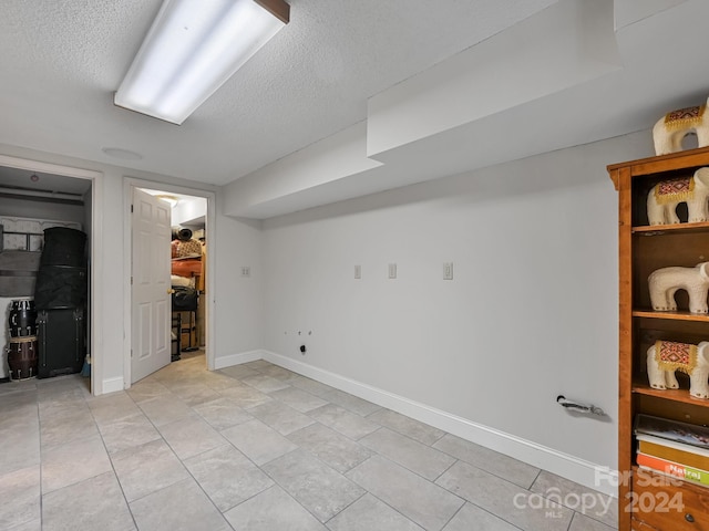 basement featuring a textured ceiling and light tile patterned floors