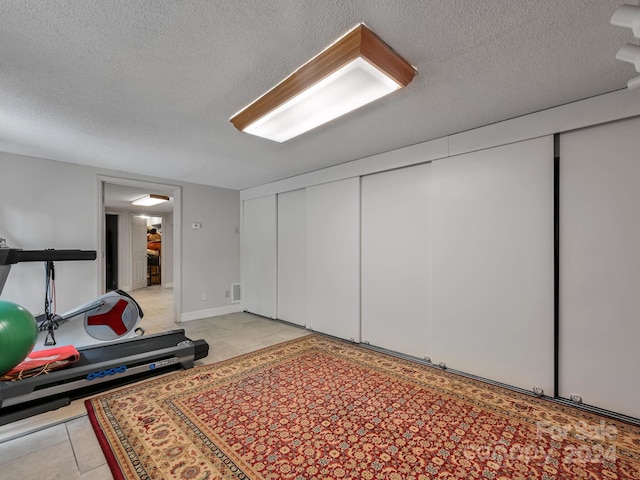 interior space featuring a textured ceiling and light tile patterned floors