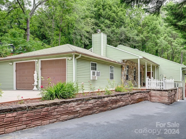 view of front facade featuring a garage and cooling unit