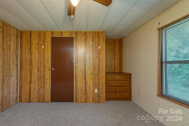 unfurnished bedroom featuring carpet flooring, a textured ceiling, and ceiling fan