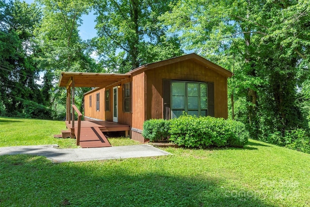 back of property featuring a lawn and a deck