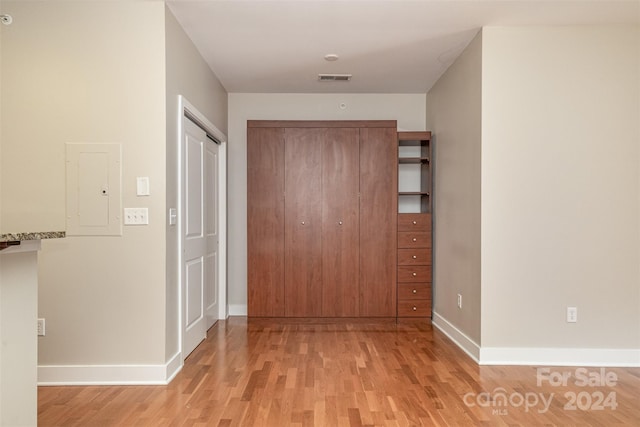 hall featuring electric panel and light hardwood / wood-style flooring