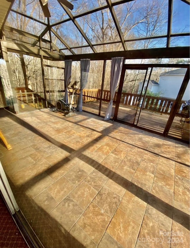 unfurnished sunroom featuring ceiling fan