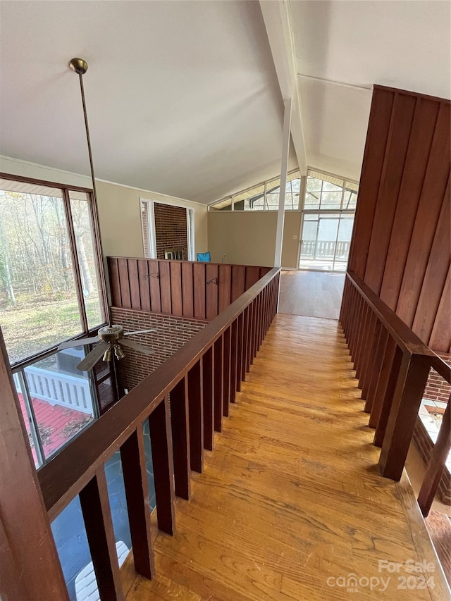 stairs with lofted ceiling with beams and wood-type flooring