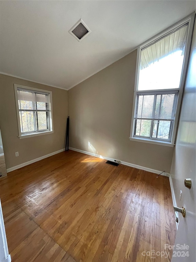 empty room featuring hardwood / wood-style floors and ornamental molding