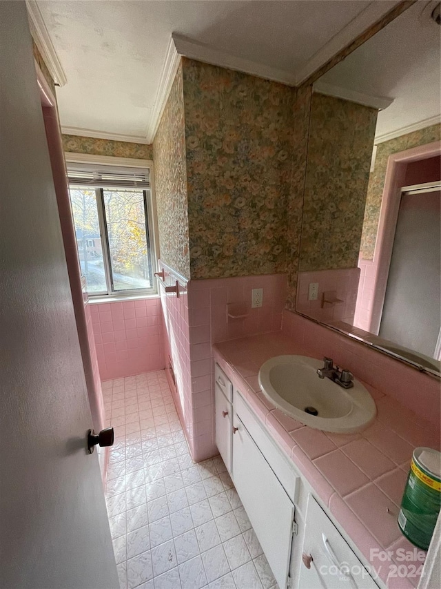 bathroom featuring tile patterned floors, vanity, ornamental molding, and tile walls