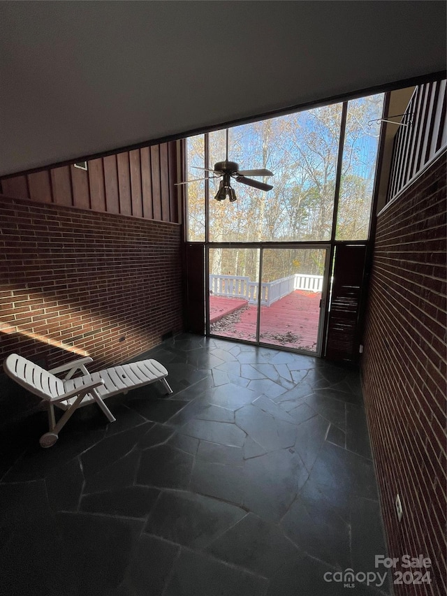 unfurnished sunroom with ceiling fan