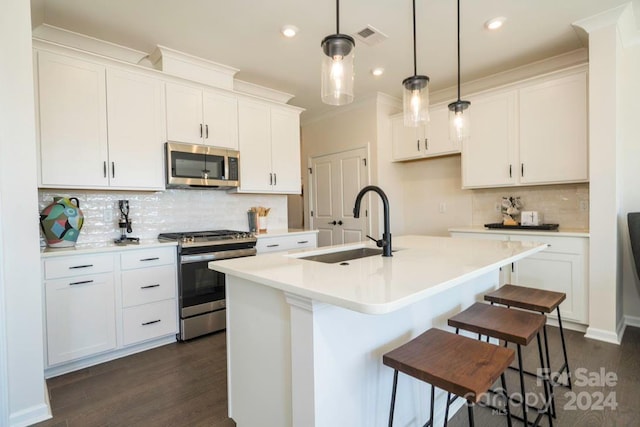 kitchen with white cabinetry, an island with sink, hanging light fixtures, and appliances with stainless steel finishes