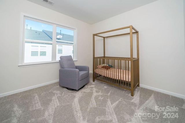 carpeted bedroom featuring a nursery area