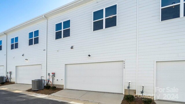 view of property exterior with a garage and central air condition unit