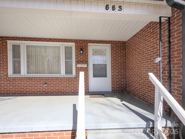 entrance to property featuring brick siding