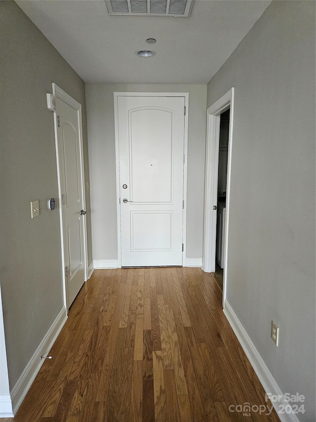 hallway with hardwood / wood-style floors