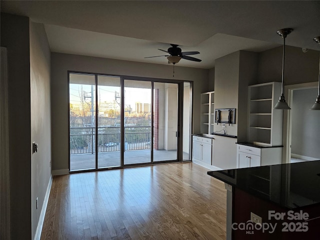 kitchen with ceiling fan, pendant lighting, white cabinets, and light wood-type flooring