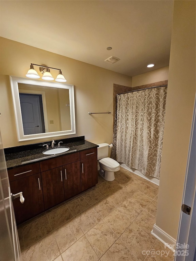 bathroom with vanity, curtained shower, and toilet