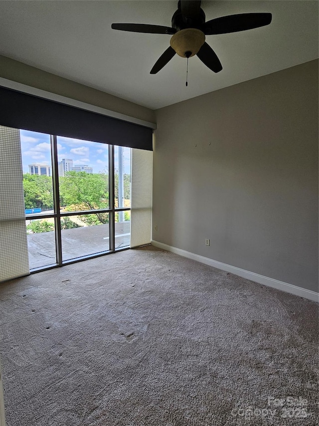 carpeted spare room featuring ceiling fan