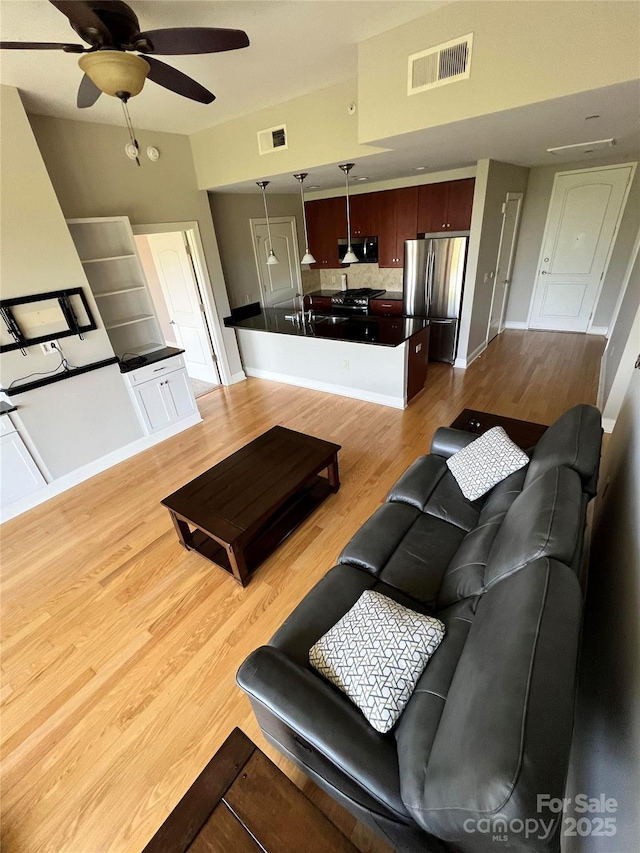 living room with ceiling fan and light hardwood / wood-style flooring