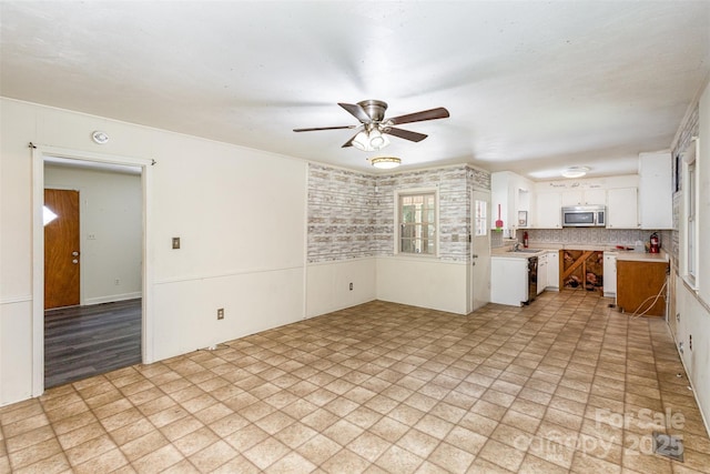 kitchen featuring tasteful backsplash, white cabinetry, sink, and ceiling fan