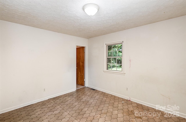 unfurnished room featuring a textured ceiling