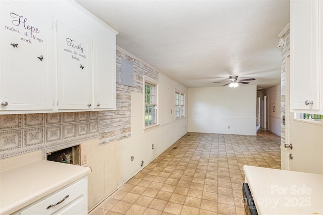 kitchen featuring ceiling fan and white cabinetry