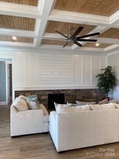 living room featuring ceiling fan, beamed ceiling, coffered ceiling, hardwood / wood-style flooring, and ornamental molding