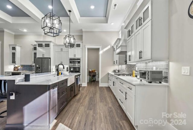 kitchen featuring white cabinetry, a breakfast bar area, stainless steel appliances, hanging light fixtures, and sink