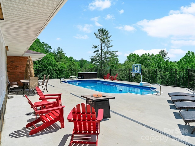 view of swimming pool with a fire pit and a patio area