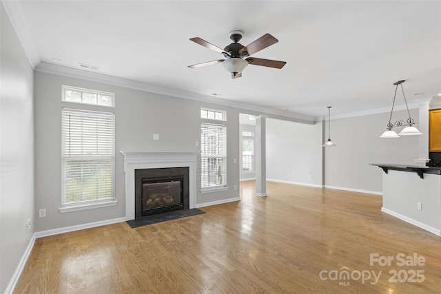 unfurnished living room with ceiling fan, a healthy amount of sunlight, crown molding, and light hardwood / wood-style flooring