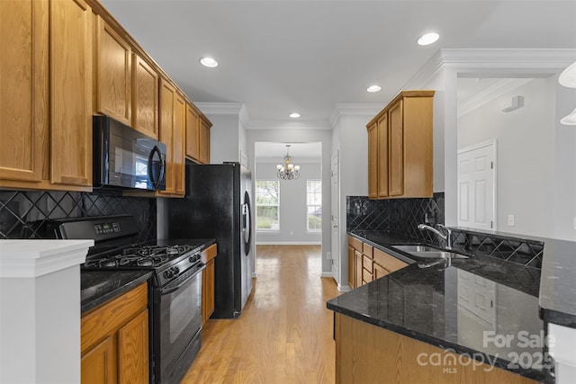 kitchen with black appliances, crown molding, sink, dark stone countertops, and tasteful backsplash