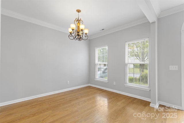 unfurnished room featuring light hardwood / wood-style floors, crown molding, and a notable chandelier