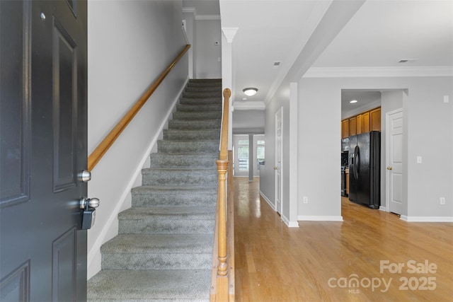 staircase with crown molding and wood-type flooring