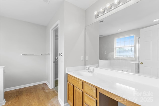 bathroom with wood-type flooring, vanity, and walk in shower