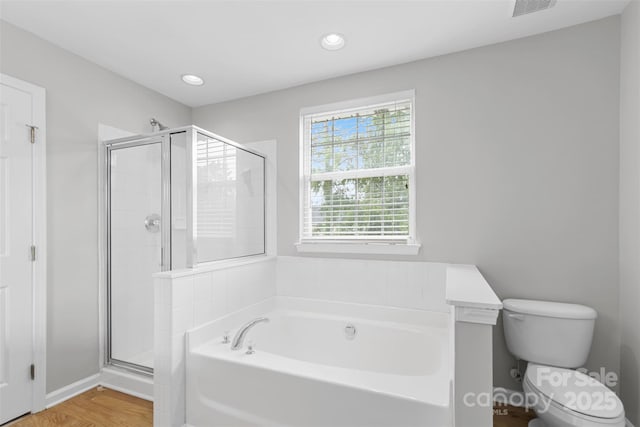 bathroom featuring toilet, hardwood / wood-style floors, and shower with separate bathtub