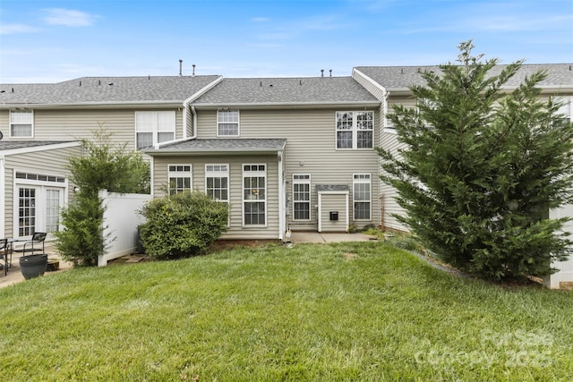 rear view of property featuring a patio and a lawn