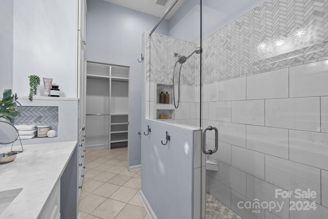 bathroom featuring tile patterned floors, vanity, and a shower with door