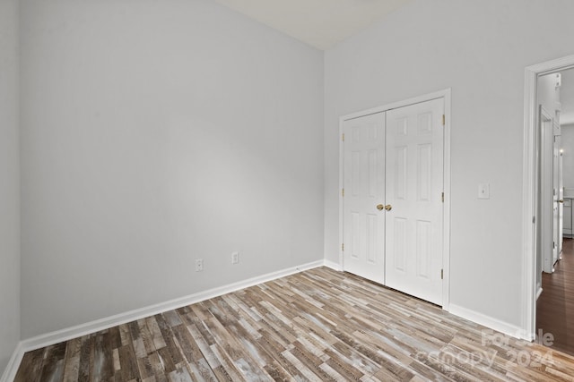 unfurnished bedroom with wood-type flooring and a closet