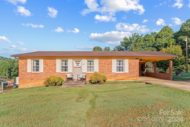 ranch-style home featuring a front lawn and a carport