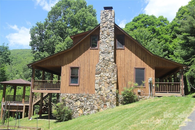 view of home's exterior with a yard and a wooden deck