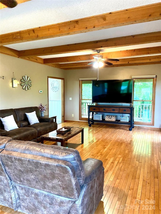 living room featuring beamed ceiling, ceiling fan, and wood-type flooring