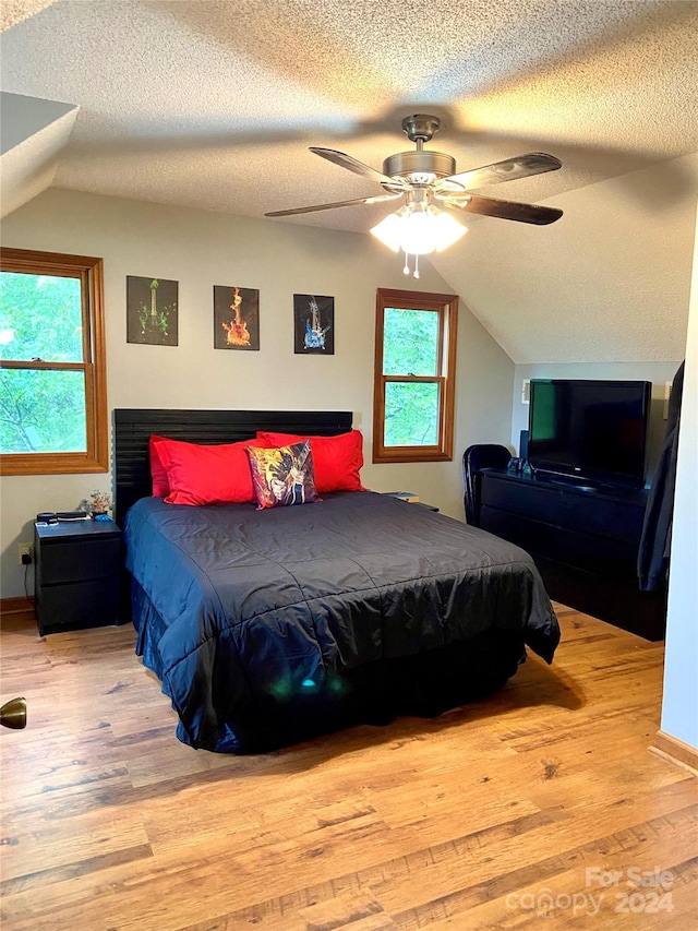 bedroom featuring hardwood / wood-style floors, a textured ceiling, and ceiling fan