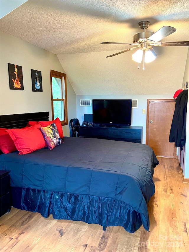 bedroom with ceiling fan, light hardwood / wood-style floors, and a textured ceiling