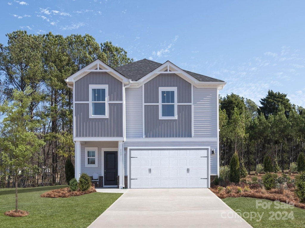 view of front of property with a front yard and a garage